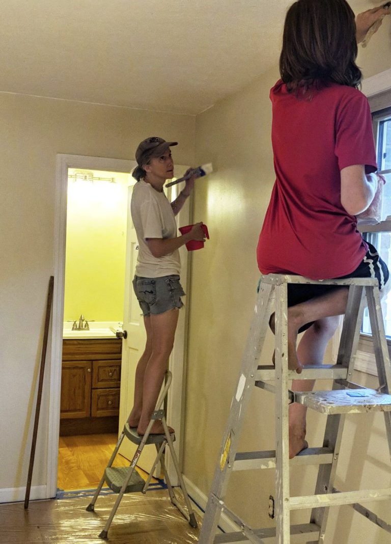 mom and son cut-in painting a room on ladders