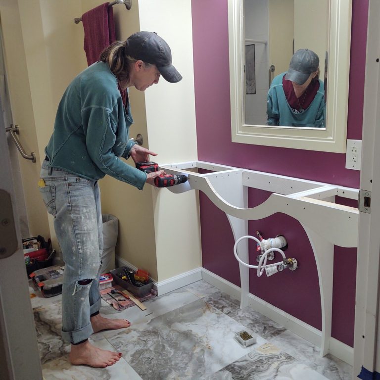 handywoman designing and painting a bathroom with woodworking